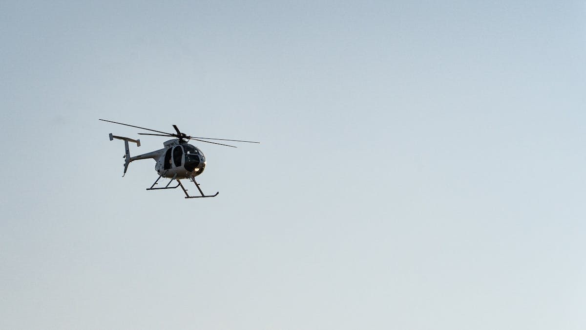 A helicopter flying in the clear blue sky above El Salvador, showcasing aviation in a serene setting.